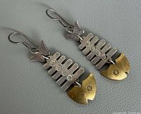 front view of articulated silver and brass fishbone earrings