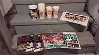 Full lot showing cups, yearbooks, posters stacked on stairs