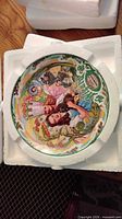 Front view of plate showing one scene with Dorothy and Munchkins