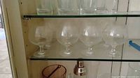 cabinet shelf with six etched brandy snifters