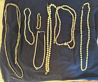 Overview of all necklaces and bracelets laid out on dark cloth
