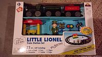Front of boxed Little Lionel Train Station Set showing contents list and dual-function feature.