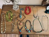 All ten necklaces laid out on table, full overview