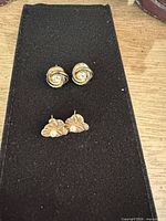 Both pairs of earrings on display pad, showing overall lot contents