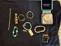 Overview of all eight bracelets laid on dark cloth