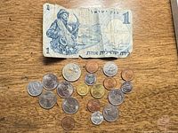 Overview of all coins and banknote on wood surface
