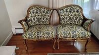 Front view of both French Provincial side chairs showing upholstery and carved frames