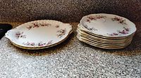 Stacks of Lavender Rose saucers and larger small plates showing floral pattern and gold trim