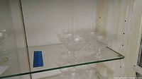 Group of coupe glasses on shelf showing quantity and etched design