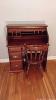 Front view of open roll-top desk with chair showing cubbies and drawers