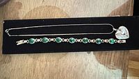 Necklace and bracelet laid out side by side showing overall design and stones