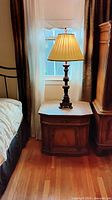 Nightstand beside bed with lamp on top