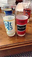 Front view showing Colt 45 and Carling Black Label glasses with others behind