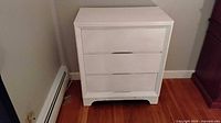 Front view of white 3-drawer dresser with drawers closed
