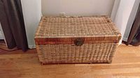 Front view of closed rattan trunk showing latch and weave