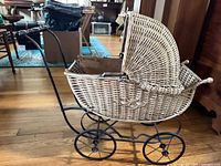 Right side view showing wicker body, canopy, metal frame and wheels