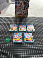 Five sealed OPC hockey card packs with display box in background