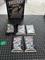Front view of all five sealed packs with retail box in background