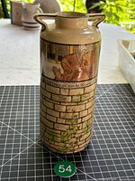 Full view of tower-shaped vase with handles and brickwork design