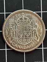 Reverse of 1958 Canadian 50 cents coin, coat of arms design visible