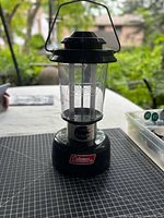 Full view of Coleman fluorescent lantern showing base, clear housing, and handle