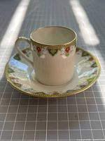 Cup and saucer full view showing pattern and gold trim