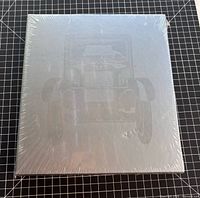 Front view of sealed hardbound book with shrink-wrap and embossed car outline