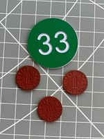 Three red OPA ration tokens with size reference disk