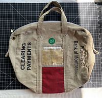 Full view of Bank of Montreal canvas money bag showing handles, zipper, document window and text