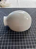 side view of white milk glass shade showing rounded body and neck