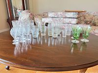 Mixed clear and green glassware on table showing overall quantity and variety