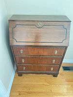 Front view closed showing three drawers and drop-front panel