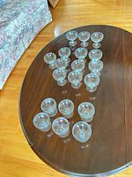 Full set of 19 clear etched coupe glasses on table