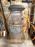 Full view of cast iron stove standing on base