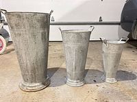 Front view of all three galvanized metal vases/planters side by side