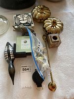 Group shot showing majority of items including brass pumpkins, napkin rings in bag, wick trimmer, marble holder, tape measure and compass