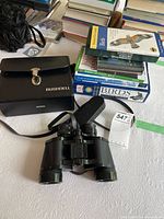 Binoculars, case, strap, stack of bird books