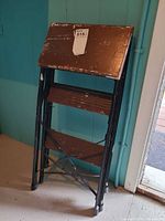 Front view folded ladder showing wood steps and metal frame