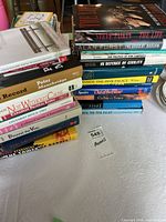 Overview of stacked hardcover books showing spines and dust jackets