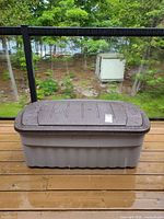 Deck box closed on deck showing exterior brown lid and gray base