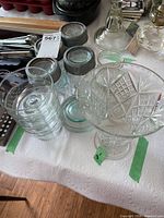Group view of four Bernardin mason jars with metal lids, four stacked dessert bowls and cut glass vase