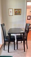 Full view of dark wood dining table with both chairs
