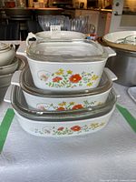 Stacked view of all three casserole dishes with lids