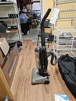 Full side view of Bissell upright vacuum with hose and power cord