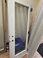 Front view of white steel door with full glass panel, lockset holes visible