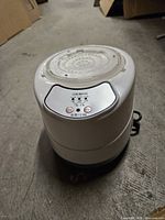 Top view of white cylindrical LED/UV nail lamp showing vented clear lid and control panel