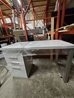 Front angled view showing desktop, drawer pedestal and metal frame