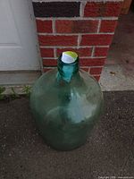 Front view of aqua/teal glass demijohn carboy standing upright