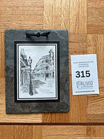Front view of slate plaque with printed artwork and rope hanger