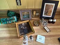Overall view of framed art, glass shakers, vanity jars and decorative plates on countertop